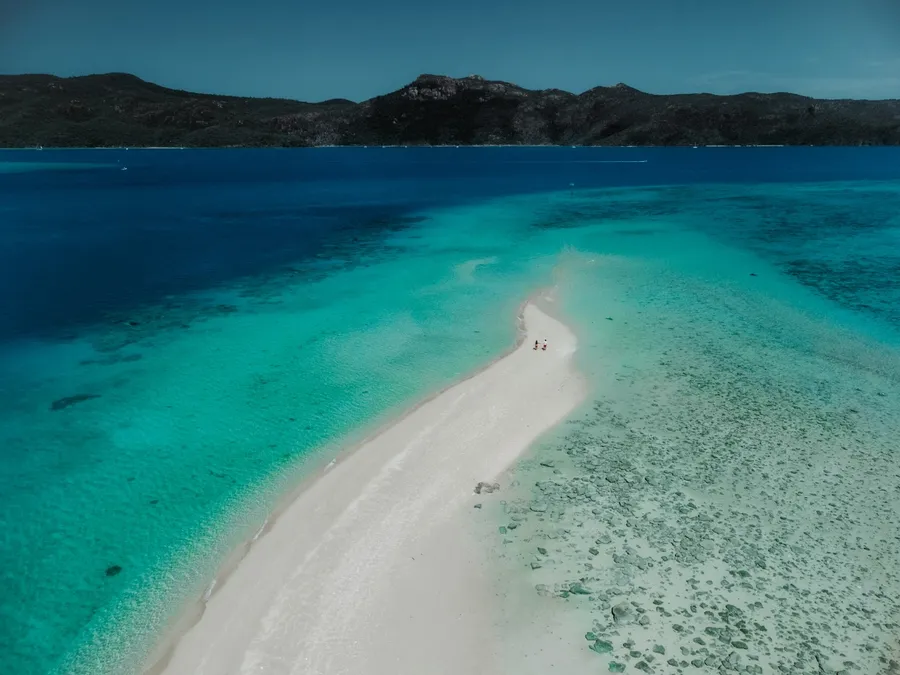 Aerial view of the Whitsundays with islands, channels, and pale sand shoals